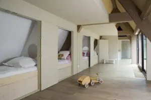 Slaapkamer met bedstedes, rechts het dakterras en linksachter vide boven keuken