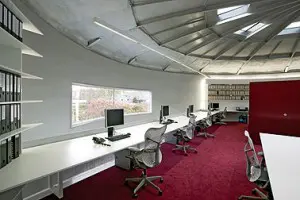 Verdieping verlicht door nieuw venster, daklichten en TL verlichting rond de gebogen boekenkasten