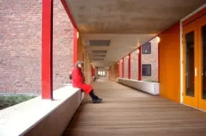 Het houten looppad op de tweede verdieping met betonnen zitelementen