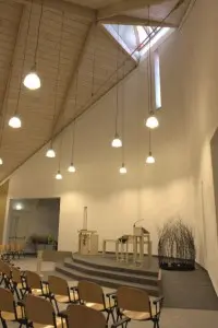 De liturgische ruimte is vormgegeven als een verhoogd stenen plateau, het plafond is bekleed met whitewashed vuren panelen