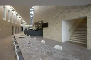 Eikenhouten blokjes in de vloer en tafel in het atrium, open trap naar verdieping. Foto Arjen Schmitz.