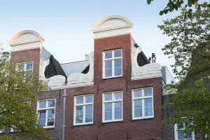 Twee halsgevels, met in de top het jaartal 2002, zijn geflankeerd door natuurstenen potvissen, de Kissing Whales