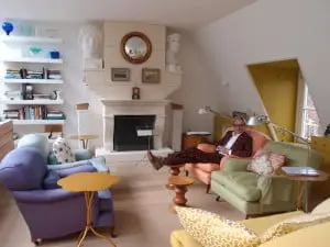 Zithoek met 19e eeuwse Engelse fauteuils. In de gebogen bladen van de tafeltjes van Eames passen je kuiten goed. In de schouw zit een TV zit verstopt. Foto Jacqueline Knudsen