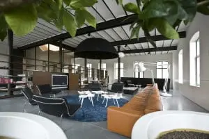 Industriële intimiteit. Ondanks de grootte van 240 m2 zit Gay Jongen met z’n kinderen ’s avonds bijna altijd in de living. ‘Op de gewenste plaats creëren we een intieme cirkel.’ De betonvloer zorgt voor continuïteit. Foto: Koos Groenewold