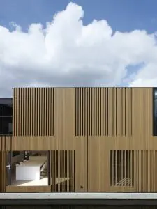 Watervilla nabij het Olympisch stadion in Amsterdam, ontwerp Framework Architecten & Studio Prototype. Het contact tussen water en woning staat centraal in het ontwerp. De verticale lattenstructuur in de gevels zorgt voor de gewenste privacy, maar ook voor een subtiel lichtspel in de woning zelf. Foto: Jeroen Musch