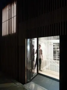 Watervilla nabij het Olympisch stadion in Amsterdam, ontwerp Framework Architecten & Studio Prototype. Het contact tussen water en woning staat centraal in het ontwerp. De verticale lattenstructuur in de gevels zorgt voor de gewenste privacy, maar ook voor een subtiel lichtspel in de woning zelf. Foto: Jeroen Musch