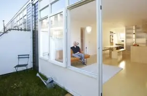 9.‘Oorspronkelijk hadden deze woningen puntdaken’, zegt Dooghe. ‘In de jaren tachtig zijn die vervangen door mansardedaken met een buitenruimte aan de oostzijde.’ De multiplexvloer loopt buiten door als terras. Een vierkant stukje gras ernaast vergroot het buitengevoel.