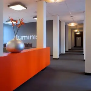 De houten lamp is een ontwerp van Luminis-medewerker Pien ter Voorde. Het heldere licht trekt de bezoekers door het midden van de loft naar de gang.