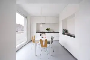 De eetkeuken aan de voorkant ligt iets hoger, ook hier zijn vele functies in de wanden weggewerkt.