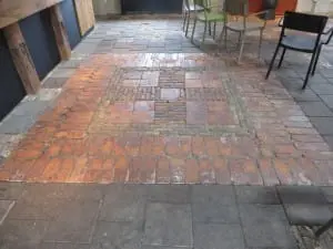 Verlaagde
vloer in de zaal, met hergebruik van oude tegels en klinkers. 