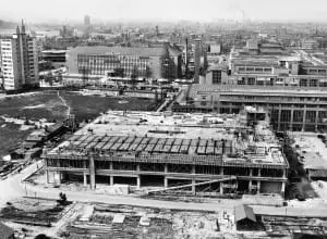 Op voorgrond het gebouw van Vroom & Dreesmann in aanbouw