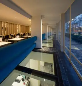 Dagcafé Mevr. Dudok zit direct na de entree. De glazen vloervensters zorgen voor daglicht in de kantoren in het souterrain.