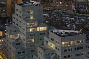 Het appartement van Ossip op de 12e verdieping heeft een beschut groot terras met aan een zijde een blinde muur. Erboven zijn nog twee lagen met penthouses.