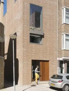 6. Voorgevel met brede deurpartij en hoog venster over twee verdiepingen. 