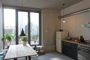 7. Eetkeuken op begane grond. De vloer ligt niet op de funderingsbalk zodat grote hoogte ontstaat en je op de balk kunt zitten.