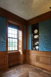 Wandbespanning van zijde boven houten lambrizeringen. De nieuwe vloer weerspiegelt het patroon van de plafonddecoraties. Foto Jacqueline Knudsen