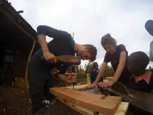 Student Pelle Rademakers en architect Argjire Krasniqi van team 1 zijn druk bezig met maken van de mal voor de compressed earth blocks