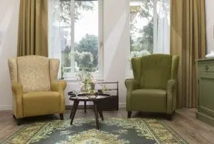 In de huiskamer is met retromeubilair een
ouderwetse sfeer gecreëerd, waarin bewoners
met dementie zich prettiger voelen. Om
struikelen te voorkomen, is het tapijt op de
vloer geprint