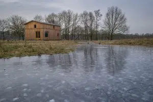 Het Oerhuis is omgeven door heide, velden en bossen, zicht vanuit oosten. Foto Jan Mateboer