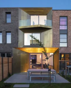 De messing gevel van Brass House steekt af bij de belendende percelen.