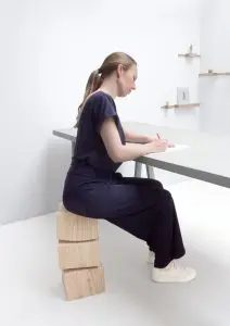 De Spine Stool vormt min of meer een verlengstuk van de ruggenwervel en bestaat uit drie geronde gestapelde larikshouten blokken. De vorm verwijst naar de actieve manier zitten op dit krukje