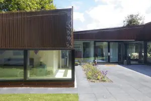 De entree ligt aan het binnenterrein en komt centraal in de woning uit op een hoge lichte ruimte