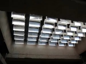 De nieuwe prismatische glasblokken sturen het licht in de onderliggende ruimte een kant op. Inzet: bovenzijde van de glasvloer