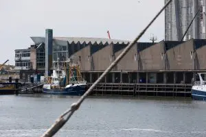 Als een slapende draak ligt de Visafslag aan de haven in Scheveningen