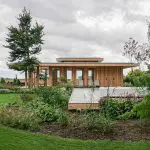 Houten buitenhuis verweven met groene omgeving