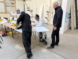 Deelnemers krijgen praktijkles van vaklieden in De Bouwpraktijk. 